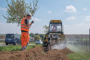 Mann in Arbeitskleidung und daneben eine Fräse.