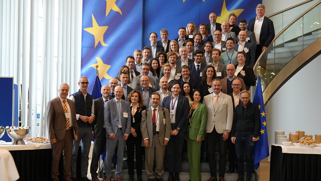 Teilnehmende der BCO-Konferenzen. Im Hintergrund ist eine Europaflagge zu sehen.