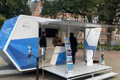 Auf dem Bild ist das Gigabit-Mobil des Gigabitbüro des Bundes zu sehen. Es zeigt unsere Expertinnen und Experten im Gespräch mit einem Bürger.
