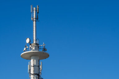 Auf dem Foto ist vor blaumen Himmel ein Mobilfunkmast zu sehen.